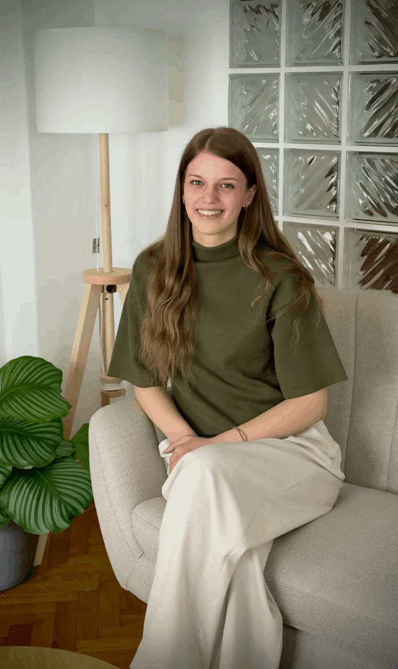 Vivi zöld pulóverben, mosolyogva